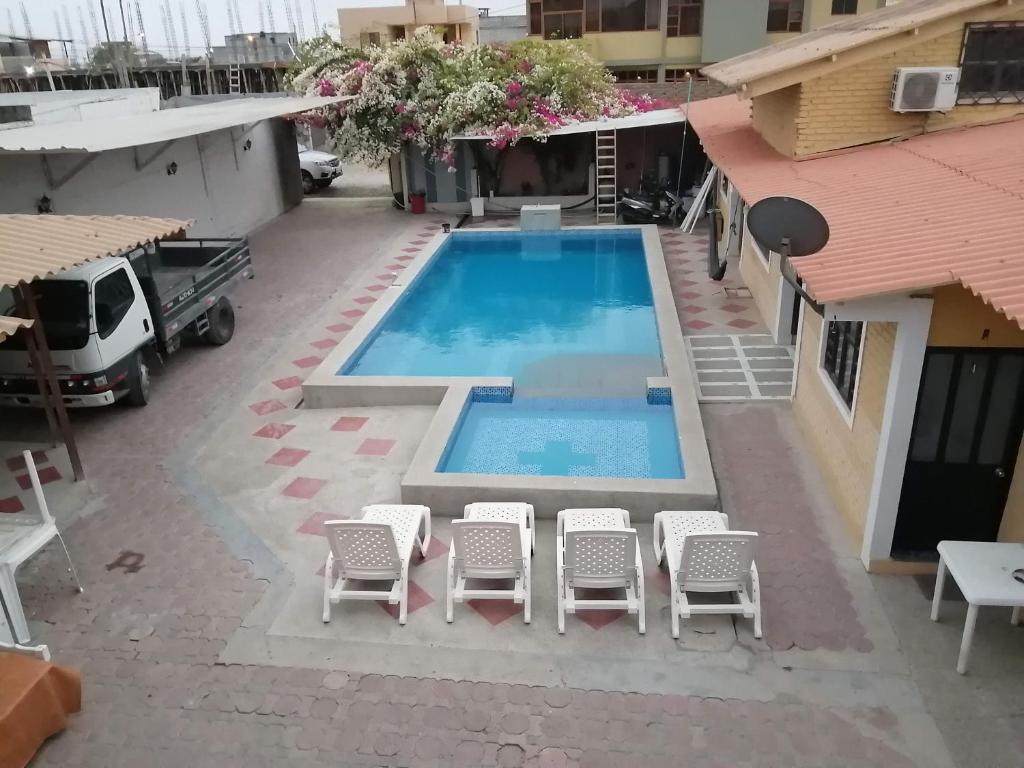 an overhead view of a swimming pool with chairs and a table at Casa Hospedaje Playas in Playas