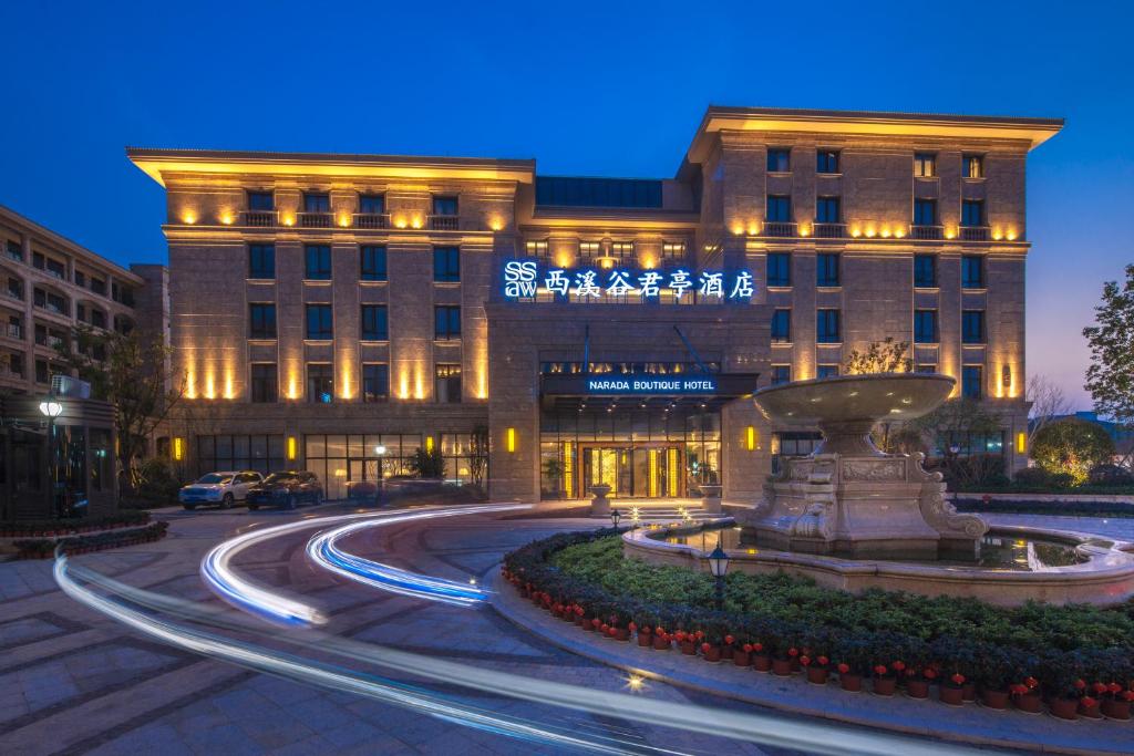 杭州的住宿－杭州西溪谷君亭酒店，一座建筑前面有喷泉