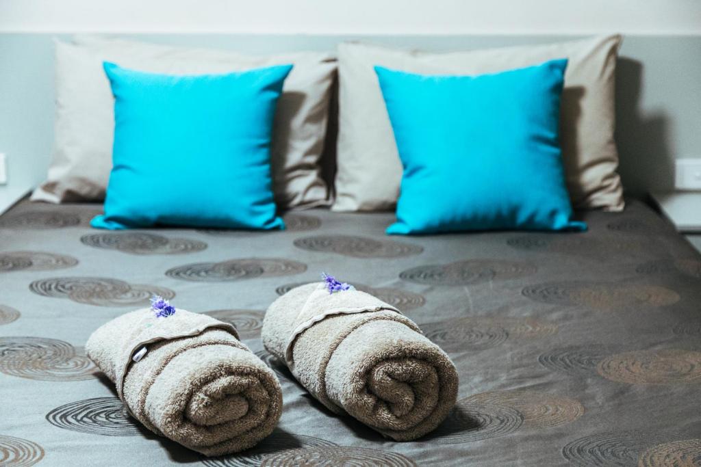 un paio di asciugamani su un letto con cuscini blu di Copper City Motel a Cobar