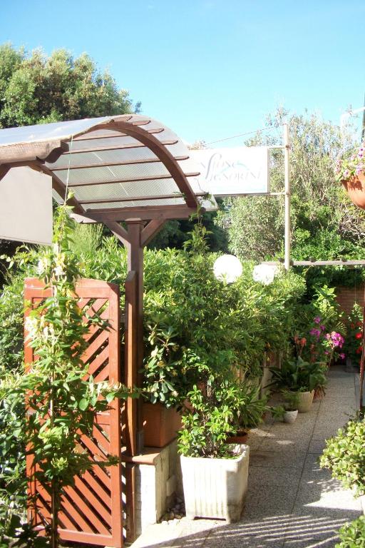 a garden with an umbrella and potted plants at Hotel Signorini in Castiglioncello