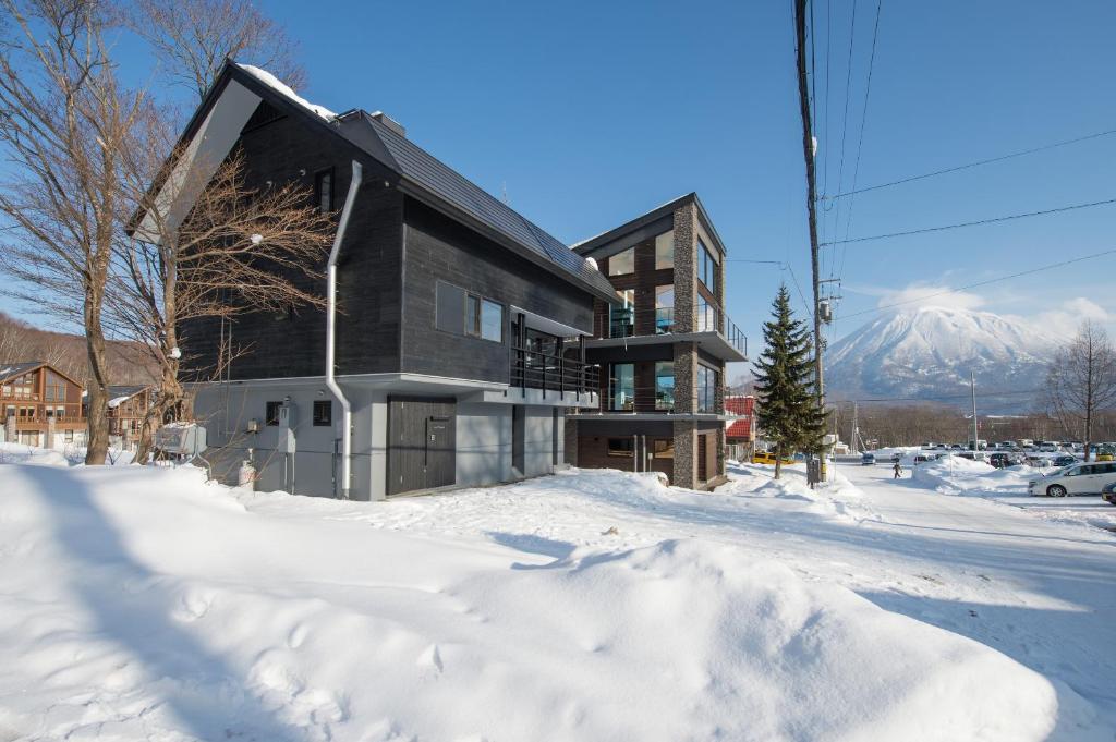 a building in the snow with a mountain in the background at La Plagne in Niseko