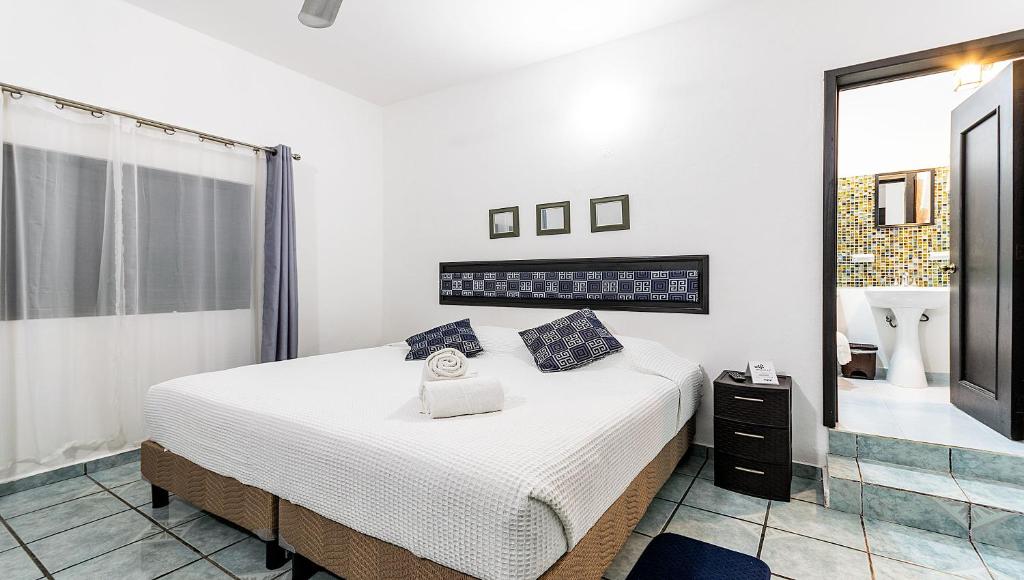 Un dormitorio con una cama grande y un espejo. en Vacation Rental - Upper Floor Room at Casa Cocoa, en Cozumel