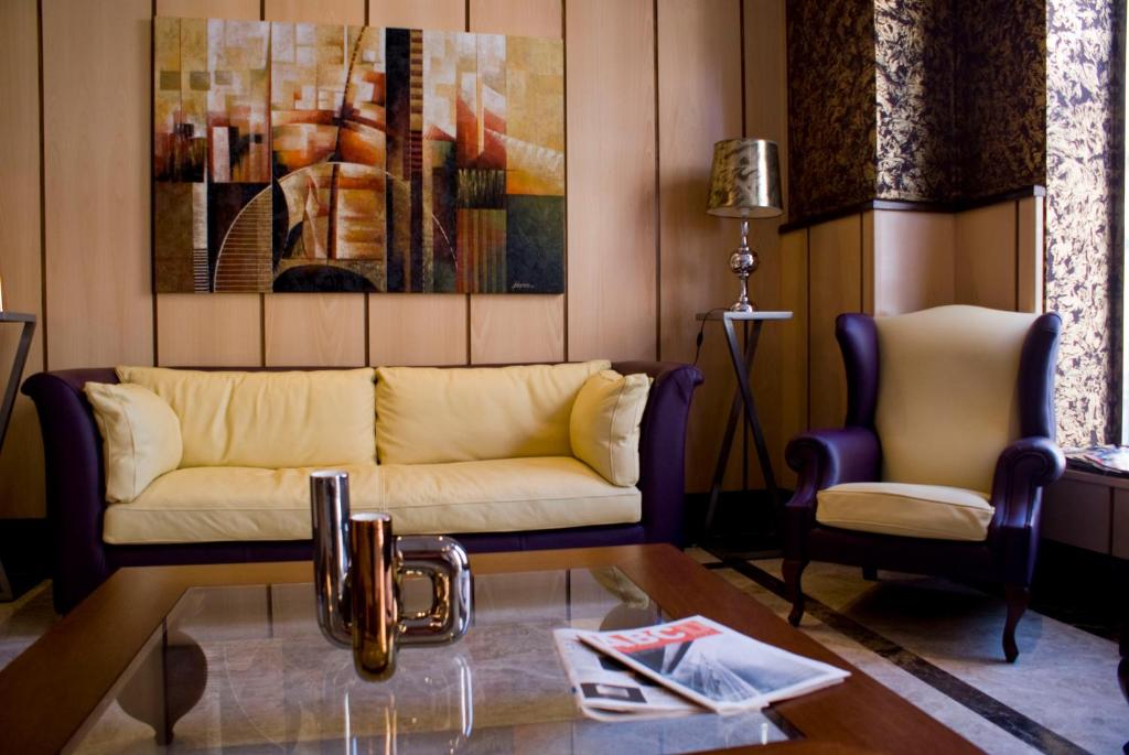 uma sala de estar com um sofá e uma mesa de centro em Hotel 4C Puerta Europa em Madri