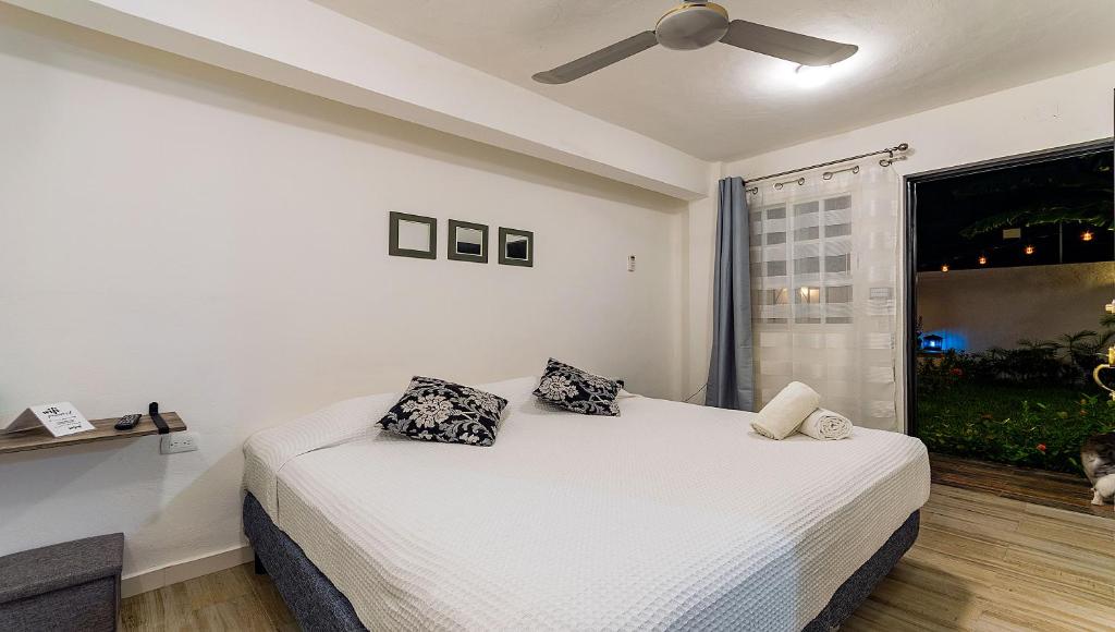 Un dormitorio con una cama con dos almohadas y una ventana. en Vacation Rental - Standard Room at Casa Cocoa, en Cozumel