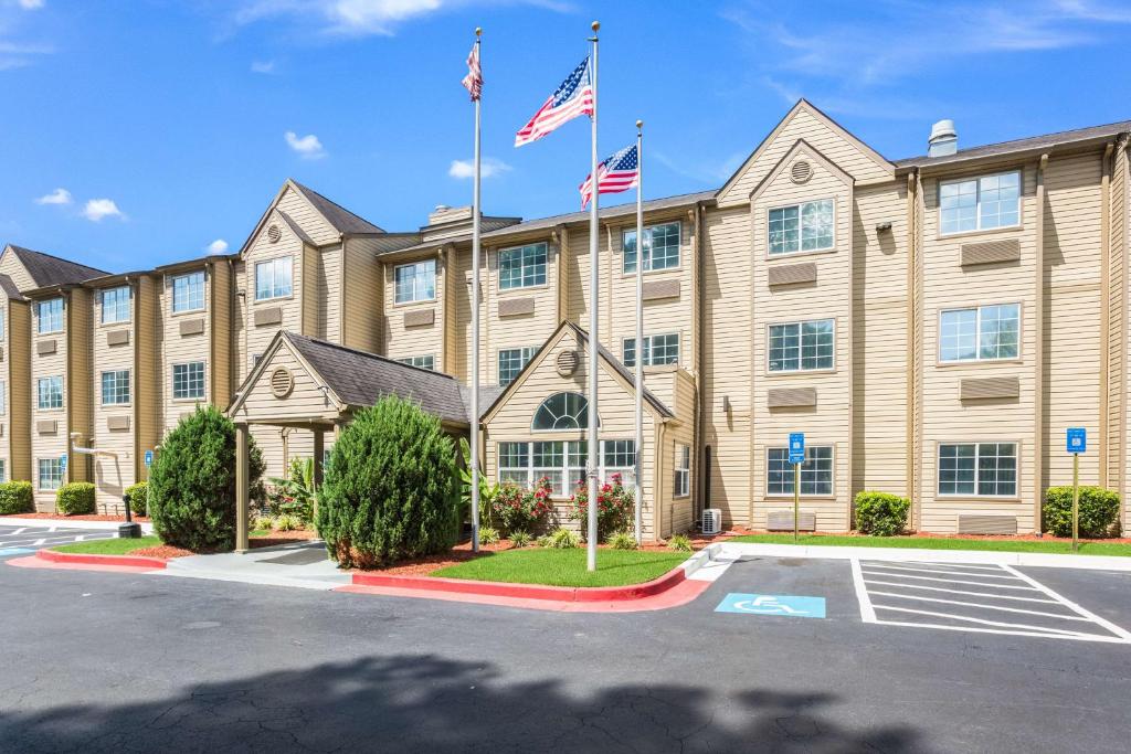 - une vue sur l'extérieur d'un hôtel avec deux drapeaux dans l'établissement Motel 6-Smyrna, GA - Atlanta, à Atlanta