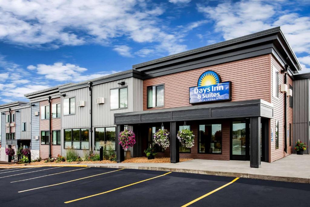 a building with a sign for a dog inn and suites at Days Inn & Suites by Wyndham Duluth by the Mall in Duluth