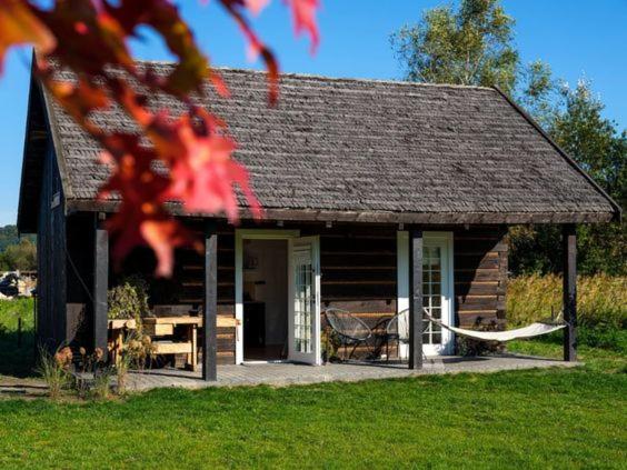 a log cabin with a hammock in front of it at Chatka w trawach in Kraków