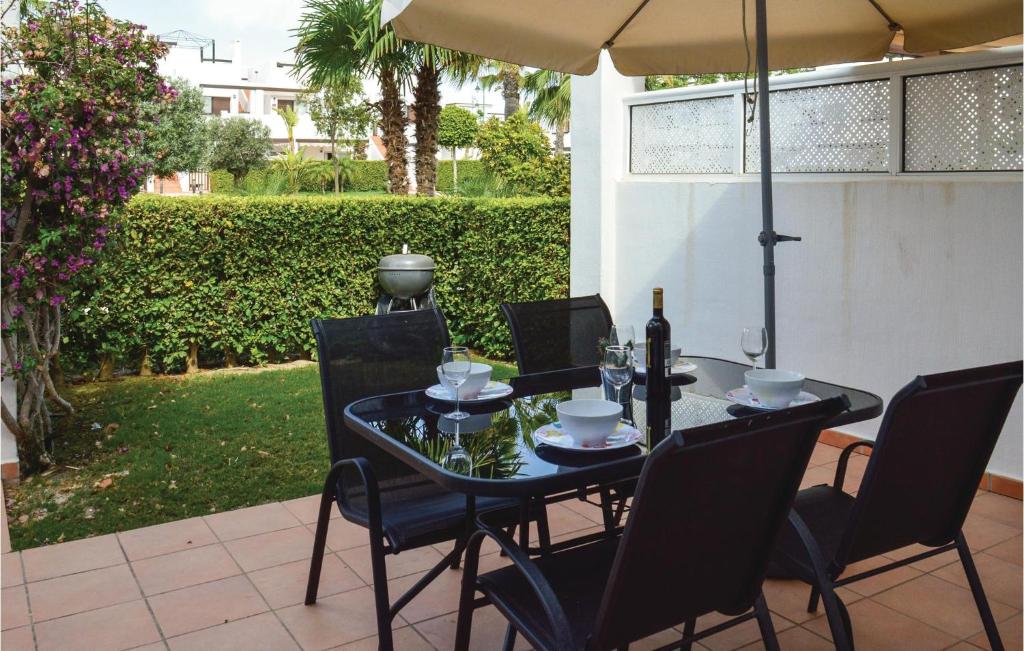 una mesa con sillas y una sombrilla en el patio en Beautiful Apartment In Alhama De Murcia With Wifi, en Alhama de Murcia