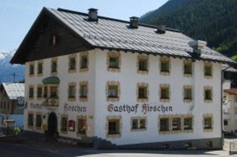 un gran edificio blanco con techo negro en Gasthof Hirschen, en Kappl