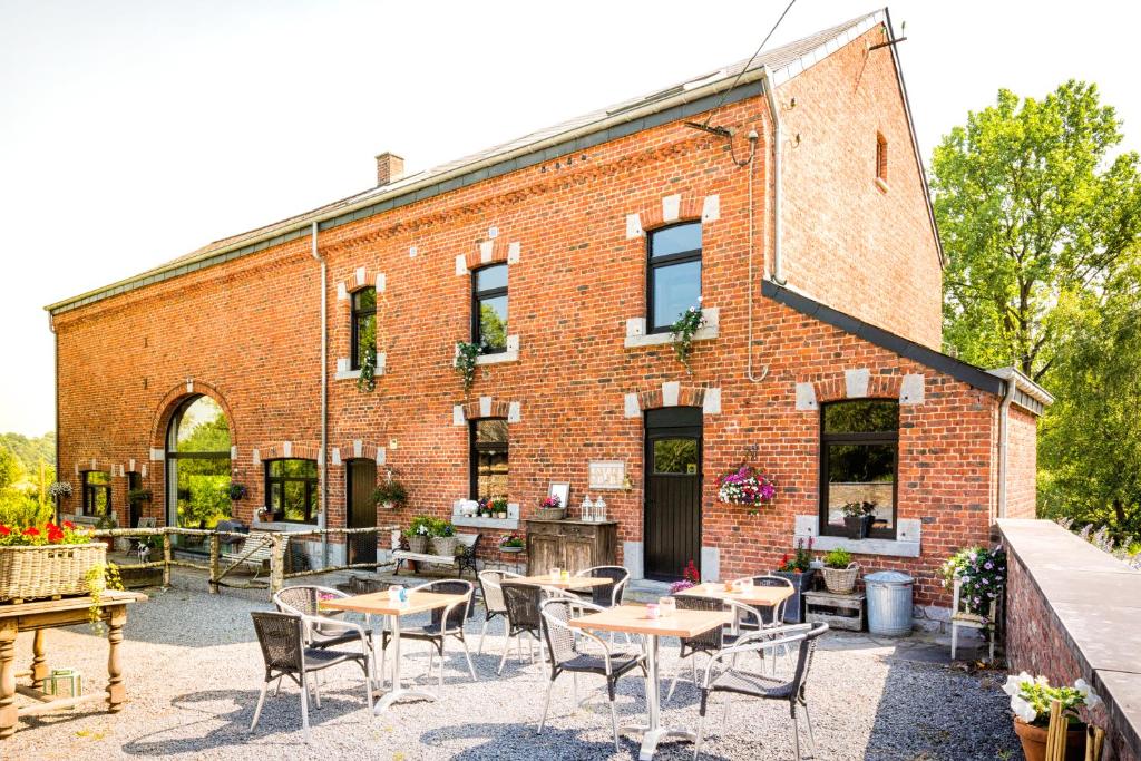 a brick building with tables and chairs in front of it at La Fleur et Le Soleil (F&S) in Durbuy