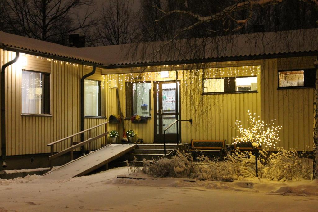 une maison jaune avec des lumières de Noël sur elle dans l'établissement Guesthouse - Kuin Kotonaan, à Kotka