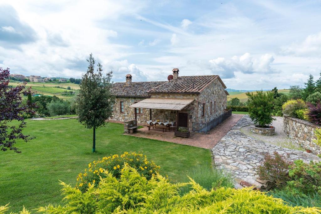 een groot stenen gebouw met een tafel in een tuin bij Aurora Agriturismo in San Casciano dei Bagni