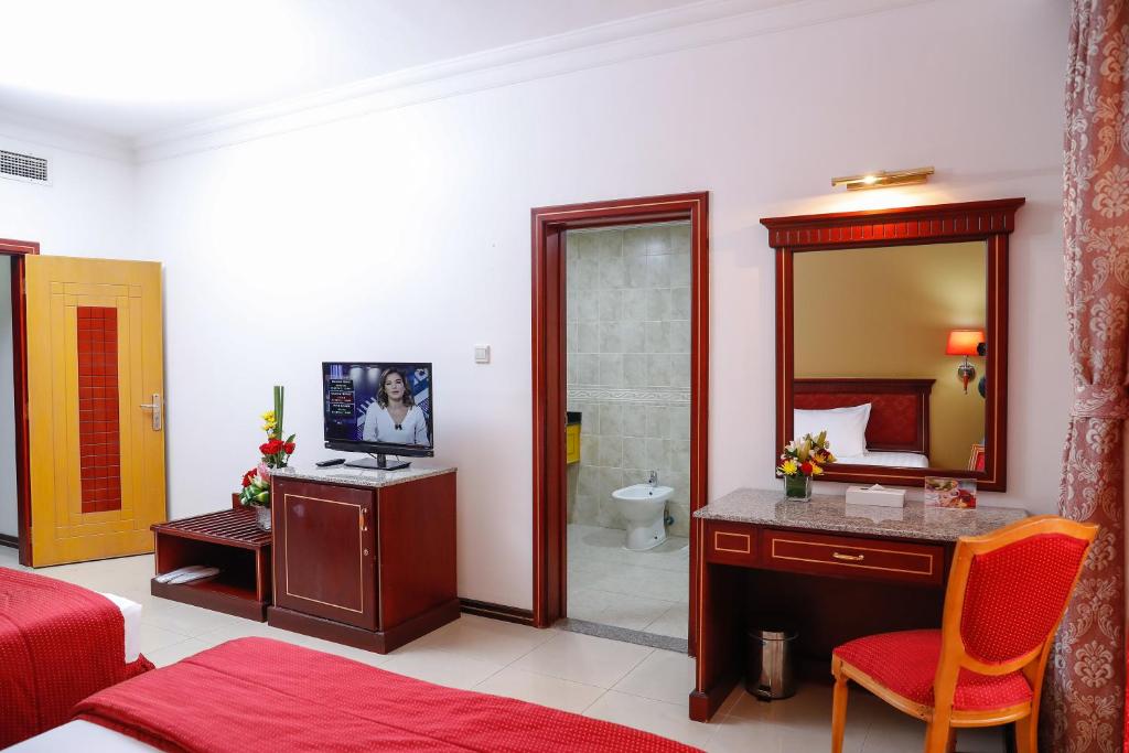 a bedroom with a bed and a bathroom with a mirror at Taj Plaza Hotel in Manama