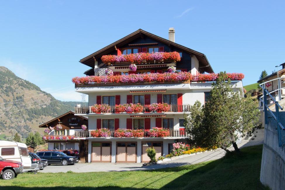 a large building with flowers on the balconies at Schmiedstube 420 in Grächen