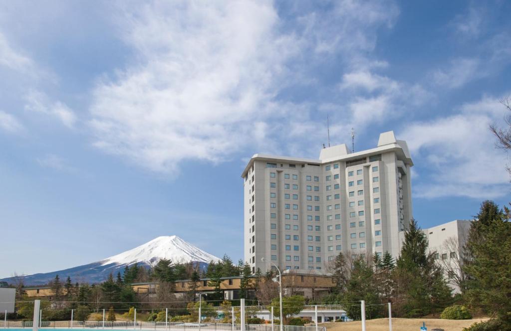 富士吉田的住宿－海蘭德水療度假酒店，一座白色的大建筑,背景是一座山