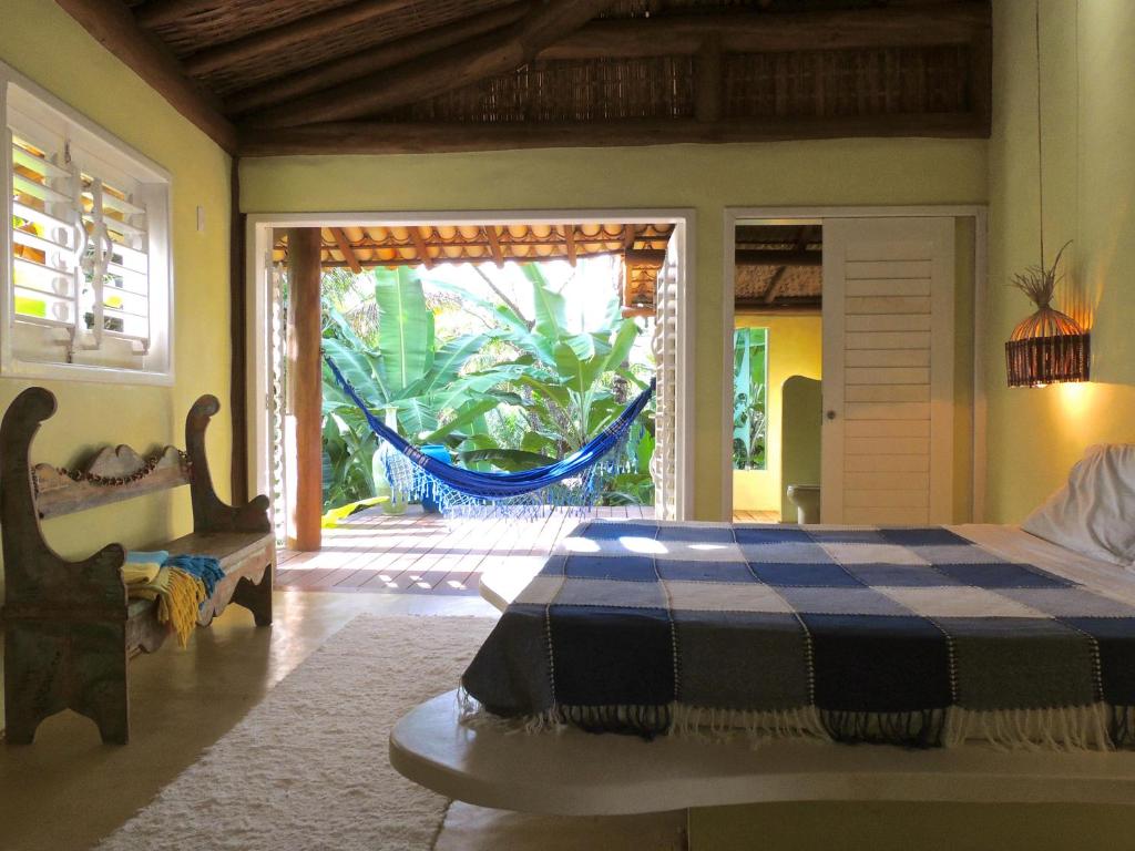 a bedroom with a bed and a sliding glass door at Nirvana Beach Hotel in Barra Grande