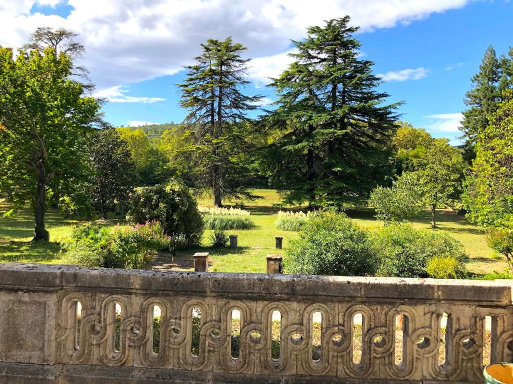 a view of a park with trees and a bridge at Le Mas de Patrice in Quissac