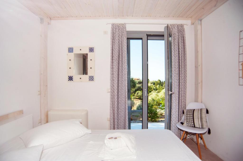biała sypialnia z łóżkiem i oknem w obiekcie LAURA_SEA VIEW_HOUSE w mieście Katouna