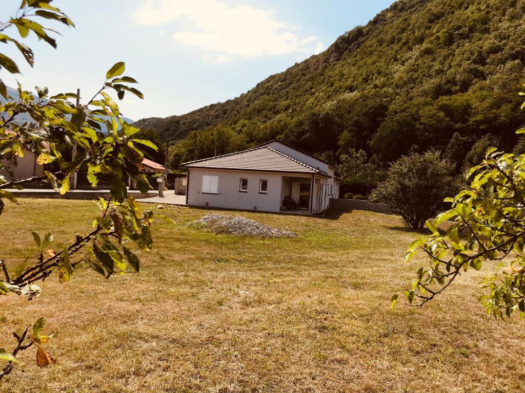 una casa en un campo con una montaña en VILLA VACANCES NEUVE en Bompas