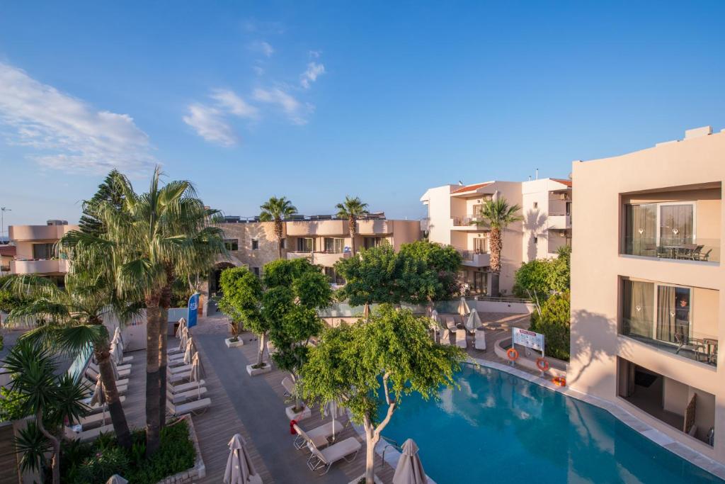 an aerial view of a resort with a swimming pool and palm trees at Cactus Beach Hotel in Stalís