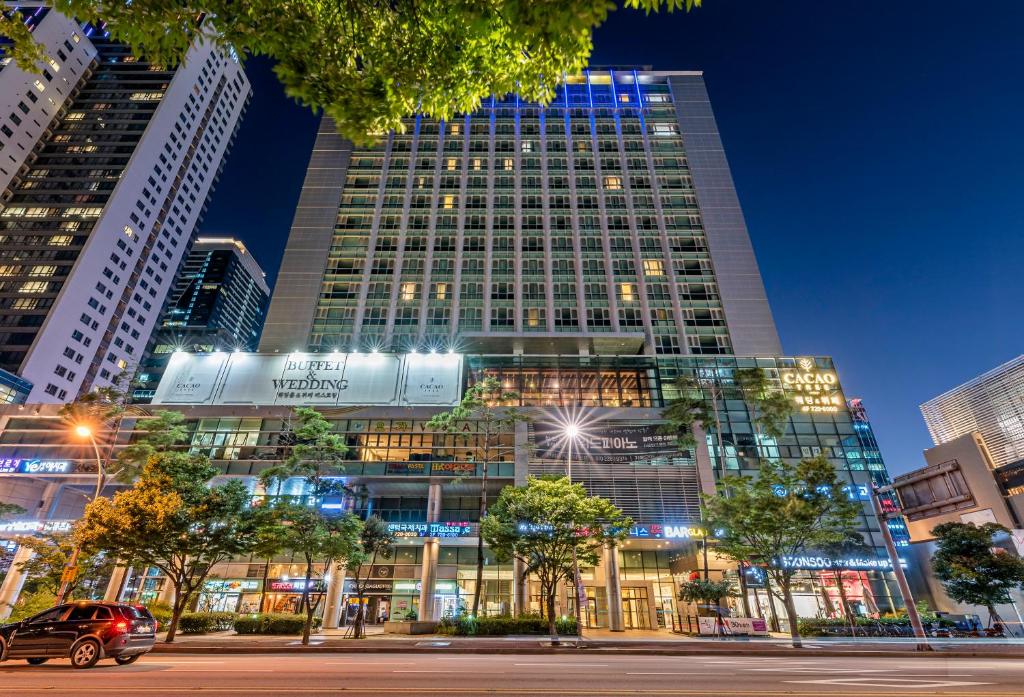 a tall building in a city at night at Haeundae Centum Hotel in Busan