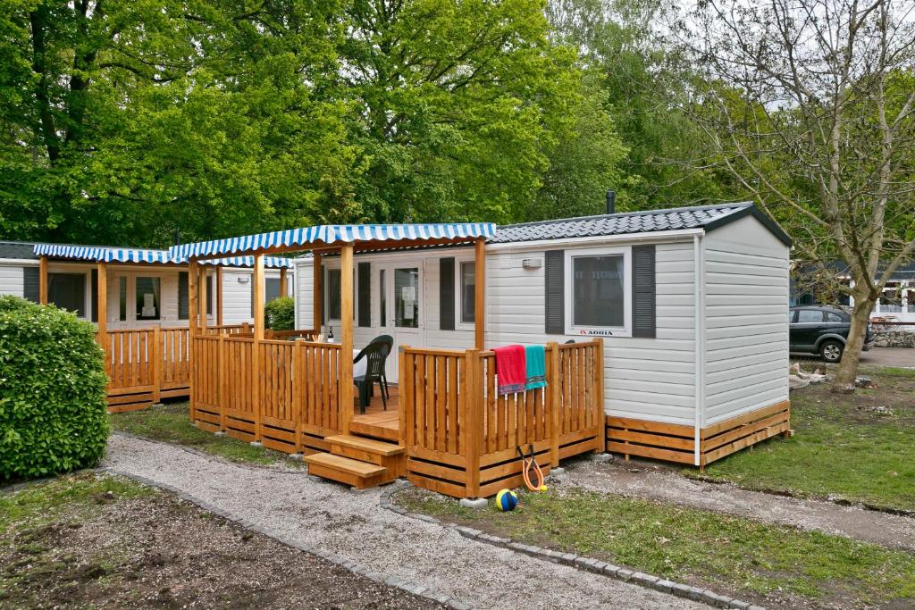 une petite maison avec une terrasse couverte et une terrasse dans l'établissement Knaus Campingpark Nürnberg, à Nuremberg