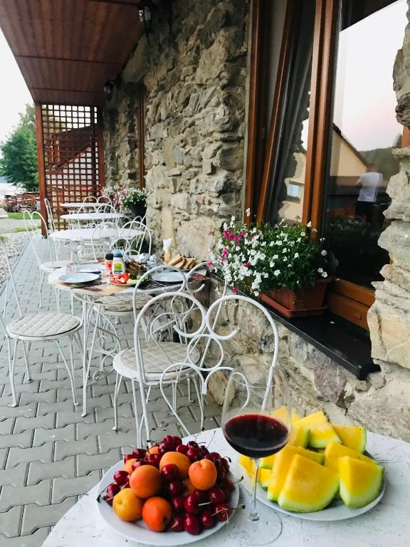 a plate of fruit on a table with a glass of wine at Mala Narnia in Frymburk