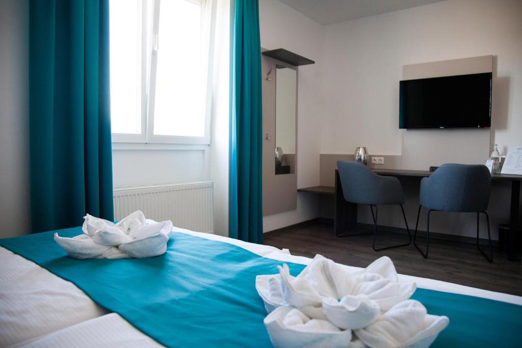 a hotel room with a bed with two white towels at Hotel im Kaiserpark in Meiningen
