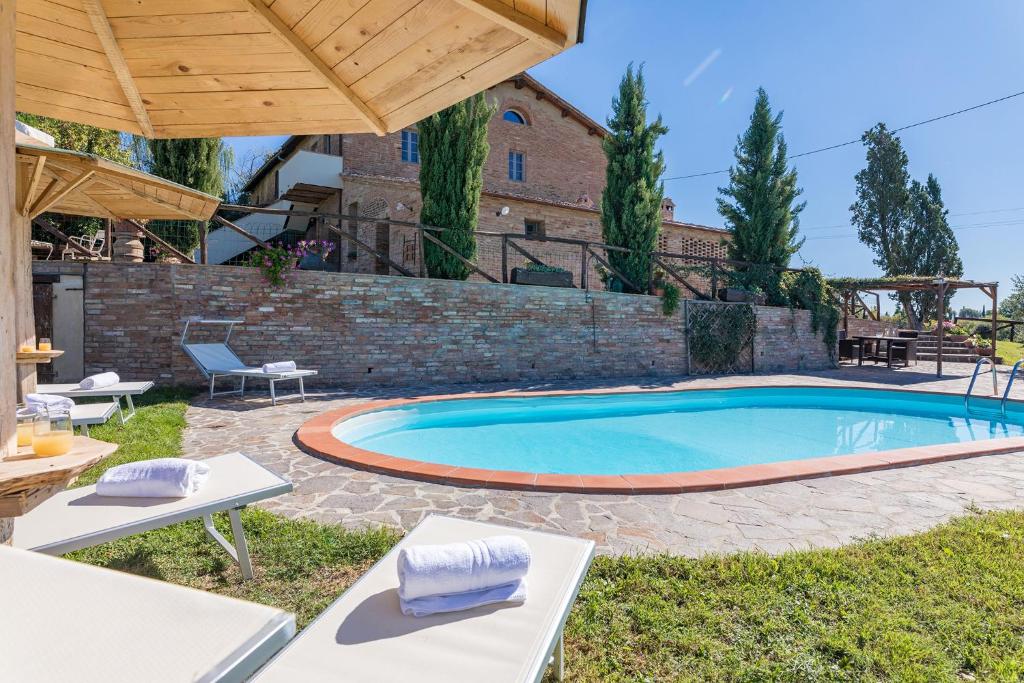 a swimming pool in a yard with tables and chairs at Podere Albereto in Buonconvento