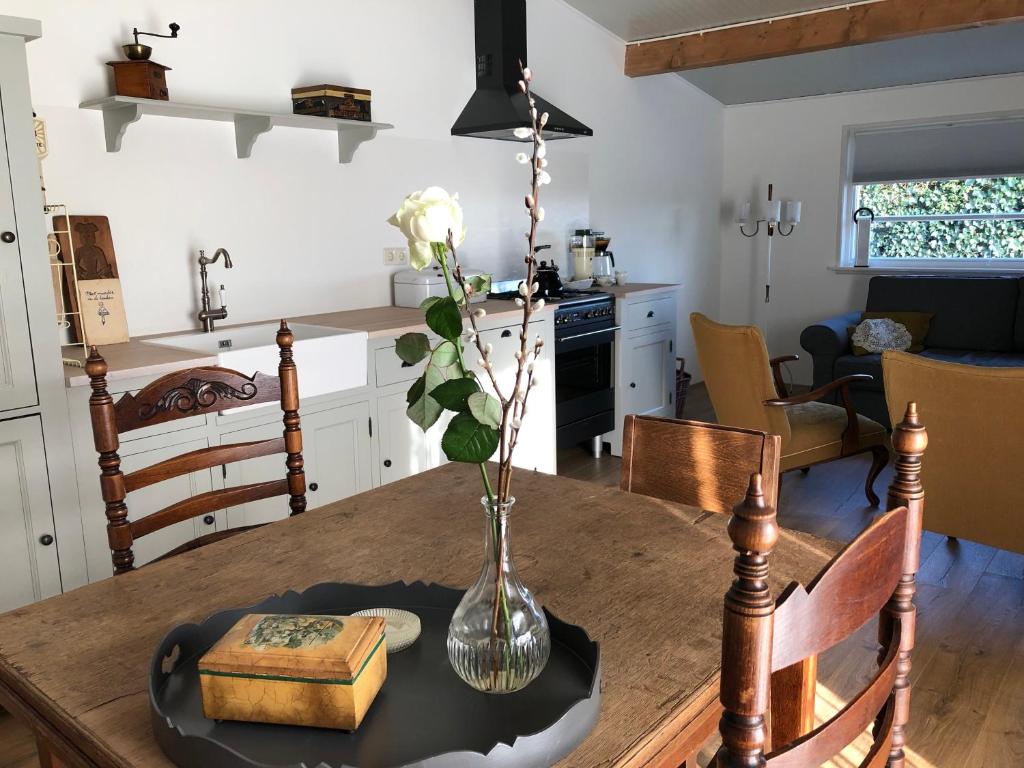 a kitchen and dining room with a table with a vase on it at Halte Bontebrug in Silvolde