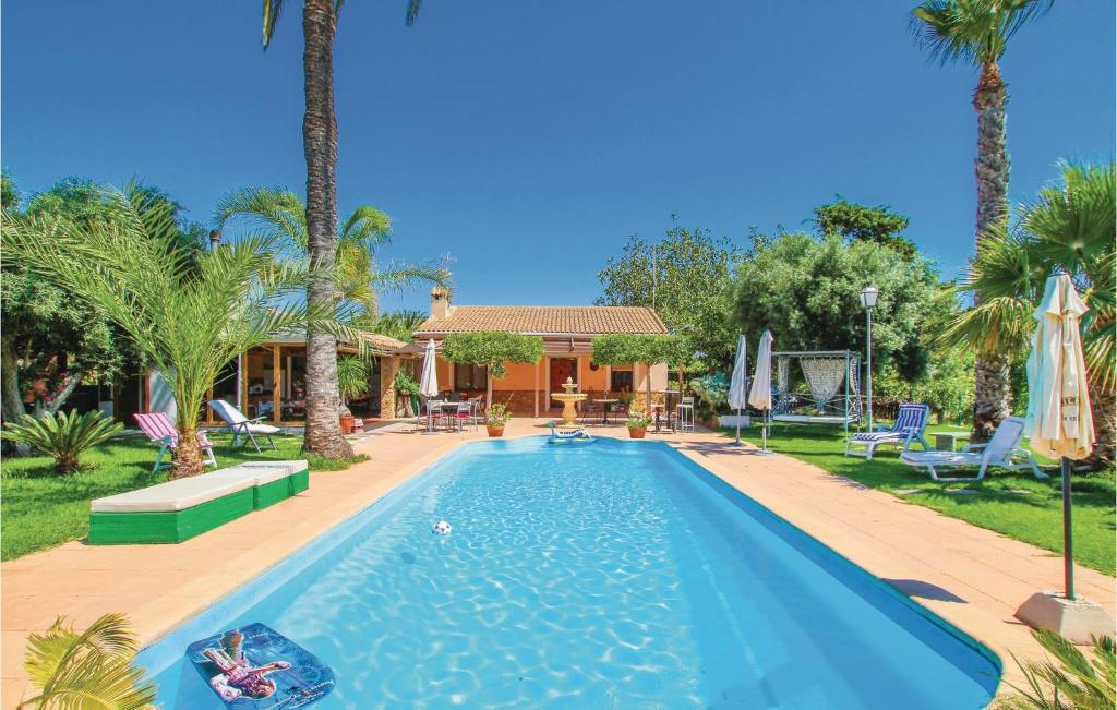 - une piscine dans une cour avec des palmiers dans l'établissement Lovely Home In La Marina, Elche With Outdoor Swimming Pool, à La Marina
