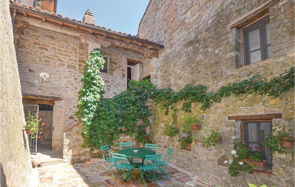 - un bâtiment en pierre avec une table et des chaises dans une cour dans l'établissement App, Greppo B, à Greppoleschieto