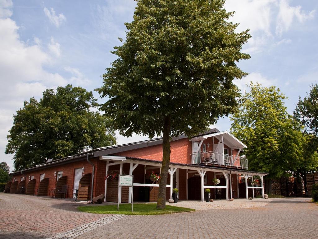 un gran edificio con un árbol delante en Gäste und Ferienhof Maas, en Dulmen