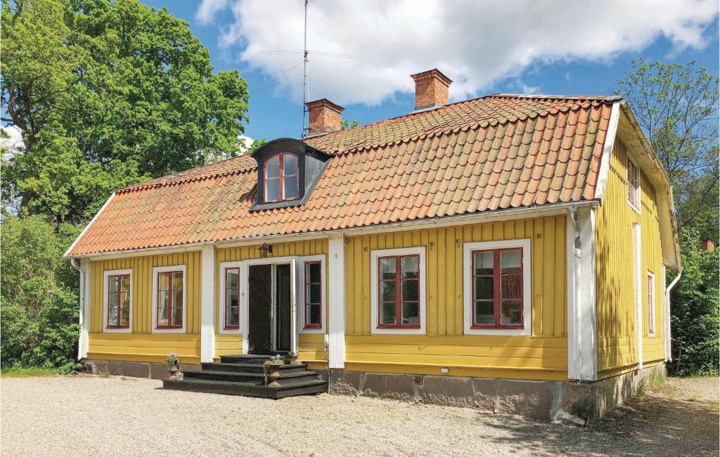 mały żółty dom z czerwonym dachem w obiekcie 4 Bedroom Gorgeous Home In Lindesberg w mieście Lindesberg