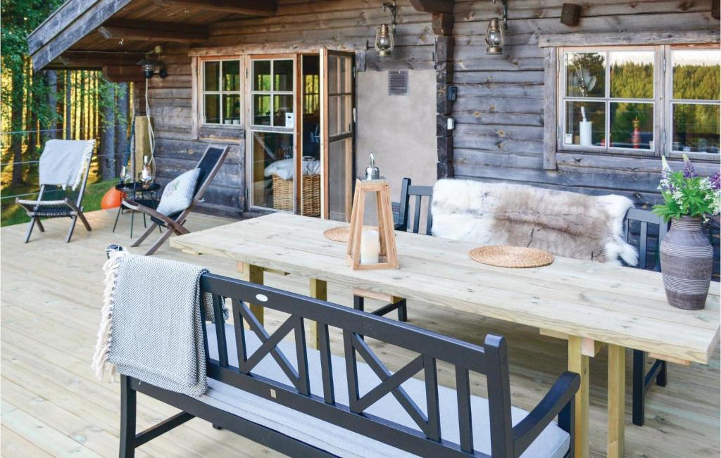 a wooden table and chairs on a deck at 2 Bedroom Awesome Home In Lnghem in Åkra