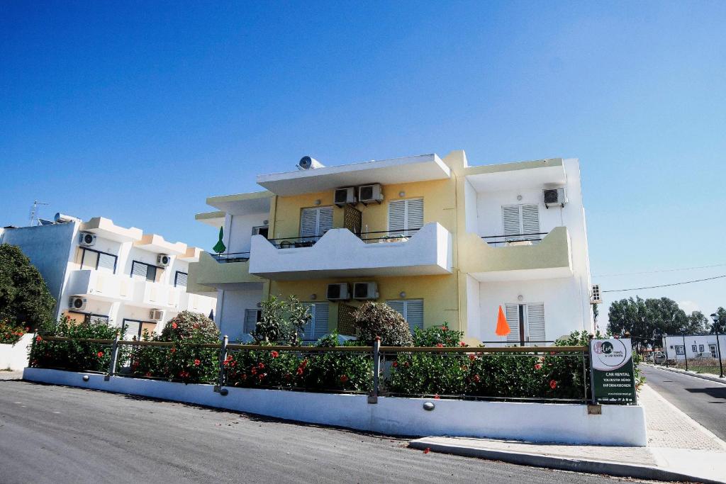 a large building with a fence in front of it at Yiannis Apartments in Mastichari