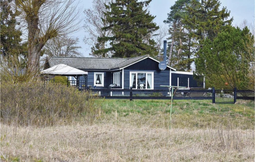 a blue house in the middle of a field at Gorgeous Home In Skivarp With Sauna in Skivarp