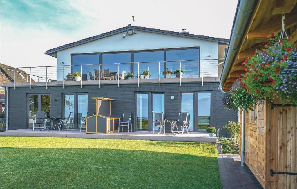 une maison dotée d'une terrasse avec des chaises et des tables dans l'établissement Cozy Apartment In Kappeln With Wifi, à Kappeln