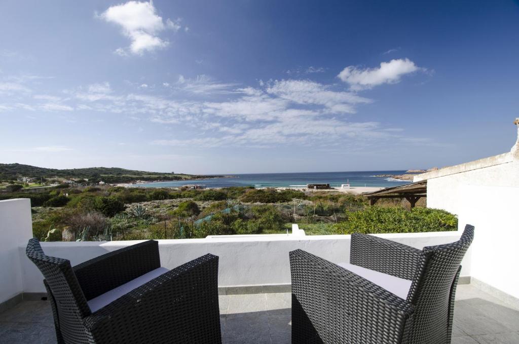 a balcony with two chairs and a view of the ocean at A.I.R. Villa Marinedda in Isola Rossa