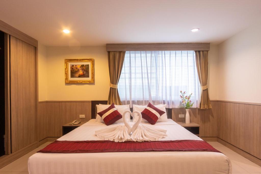 Un dormitorio con una cama con un cisne. en Gusto Pratunam Hotel, en Bangkok