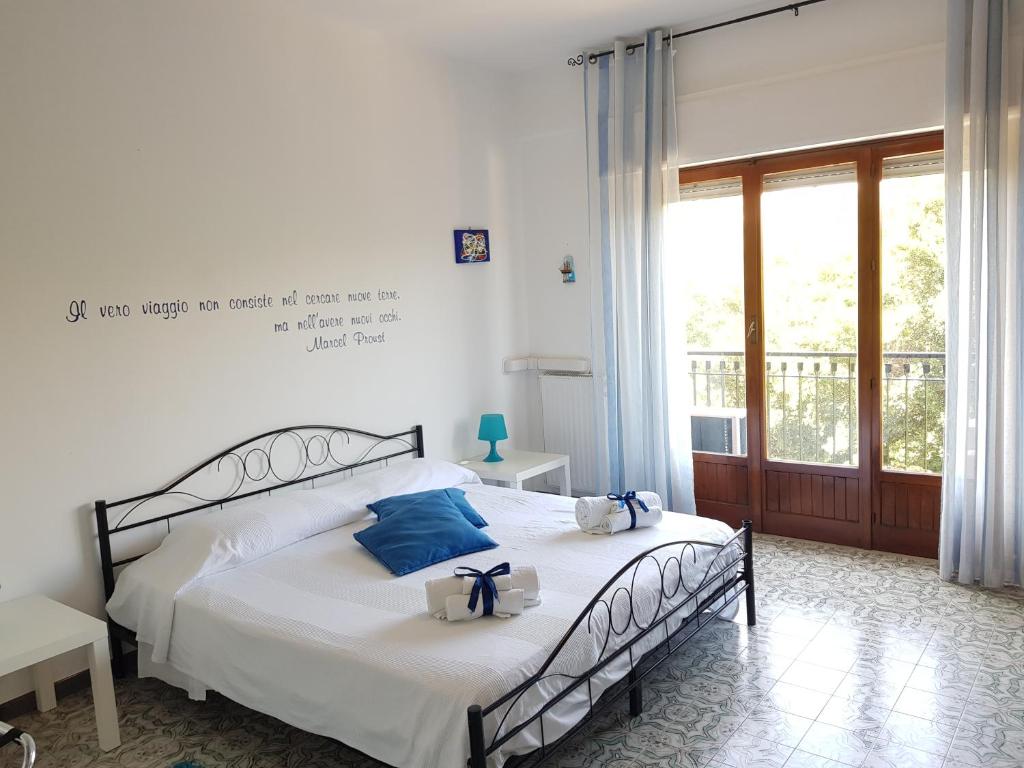 a bedroom with a bed with blue pillows on it at B&B Trapani Mare in Trapani