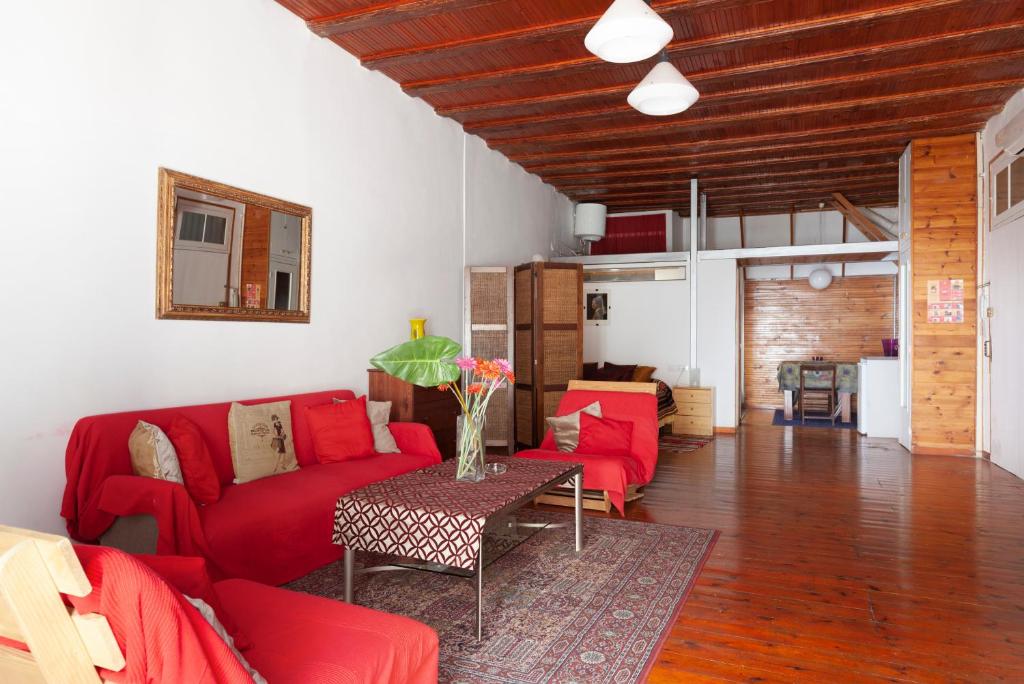 ein Wohnzimmer mit einem roten Sofa und einem Tisch in der Unterkunft Gaudí Ramblas in Barcelona