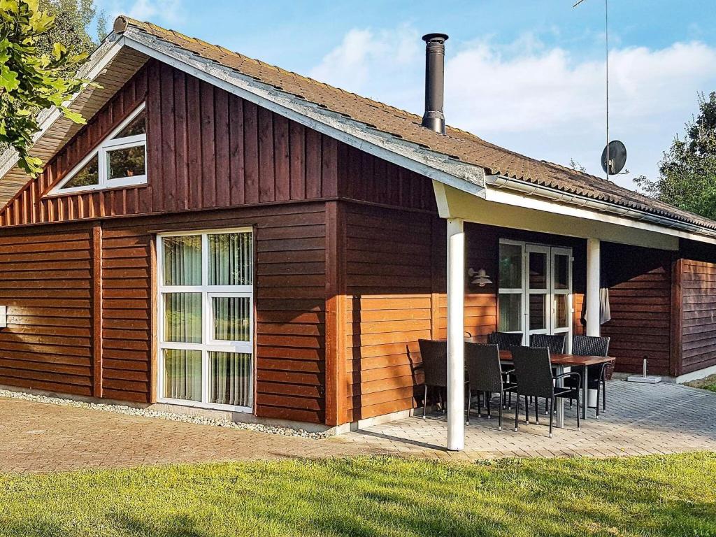 una cabaña de madera con una mesa delante en Holiday home Læsø XXIV en Læsø