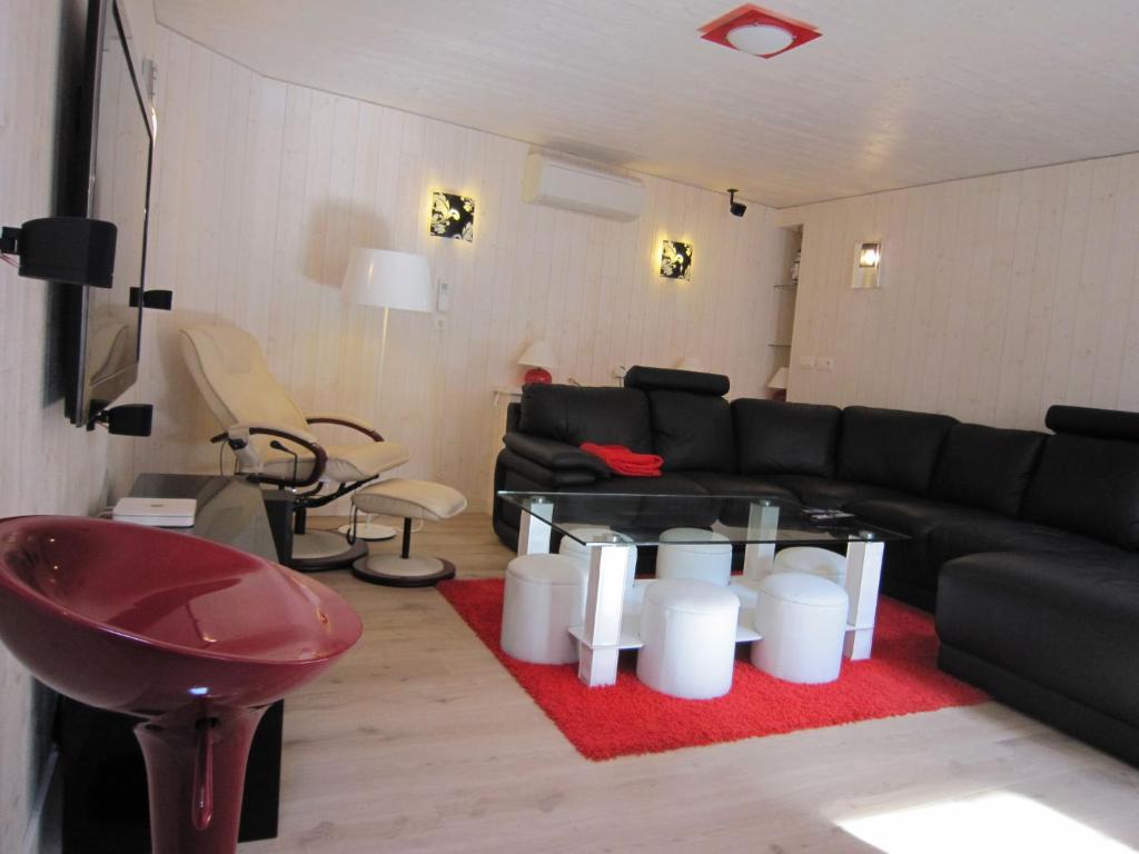uma sala de estar com um sofá preto e um tapete vermelho em Beautiful Apartment in Spa Belgium with Jacuzzi em Spa