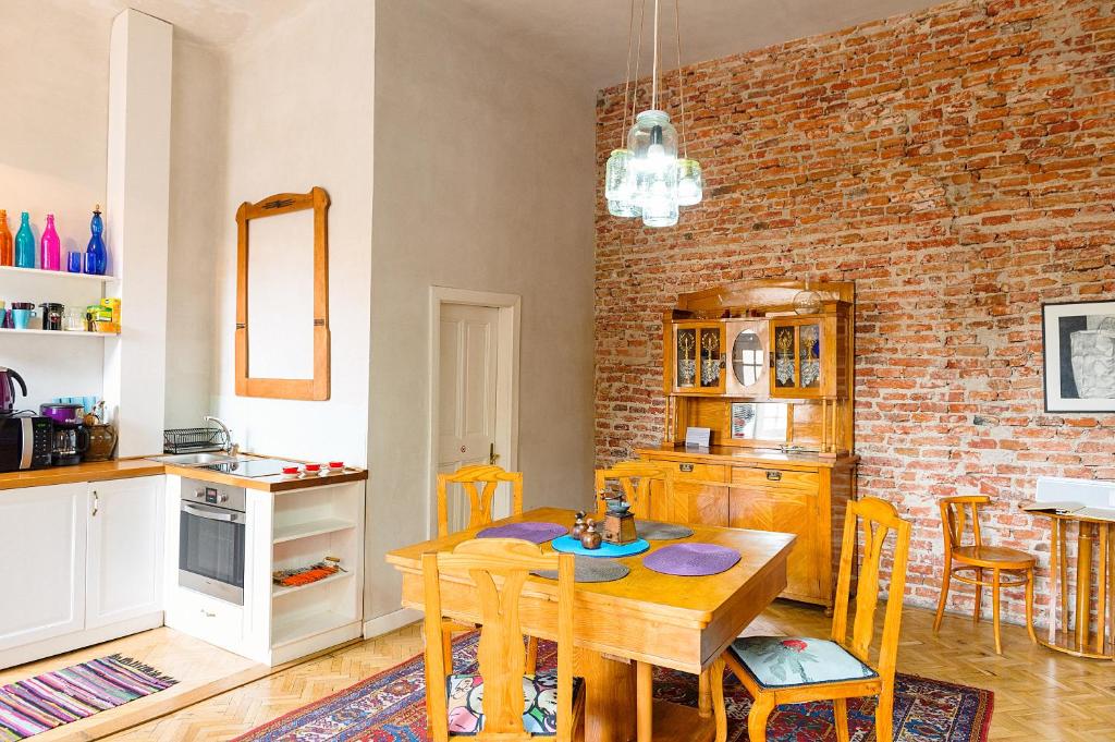 a kitchen with a wooden table and a brick wall at Cluj Apartments in Cluj-Napoca