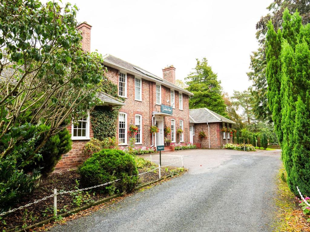 una gran casa de ladrillo rojo con entrada en The Gables Hotel en Gretna Green