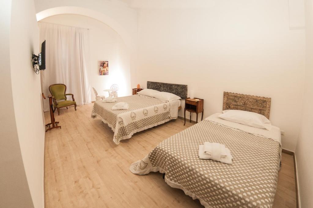 een slaapkamer met 2 bedden en een tafel en een stoel bij Casa Galione in Cava deʼ Tirreni