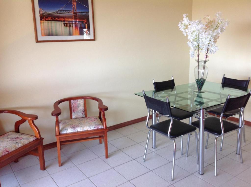 a dining room with a glass table and chairs at Praia Brava Apto 2 dorms Vista ao Mar in Florianópolis