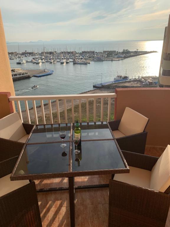 a table on a balcony with a view of the water at Penthouse Los Miradores del Puerto in La Manga del Mar Menor