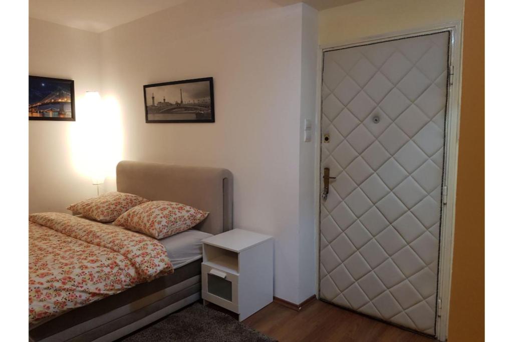 um pequeno quarto com uma cama e uma porta em Bella Centre Apartment em Belgrado